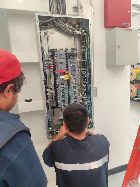 Técnicos manipulando tablero eléctrico industrial durante instalación en Aguascalientes