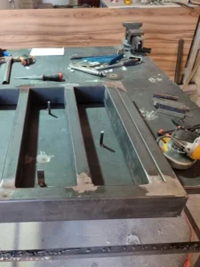 Soldadura industrial en base de transformador eléctrico durante instalación en nave industrial